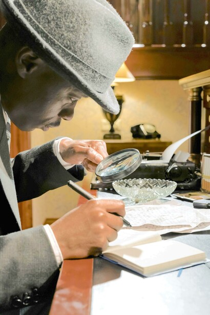 Detetive investiga pistas com uma lupa