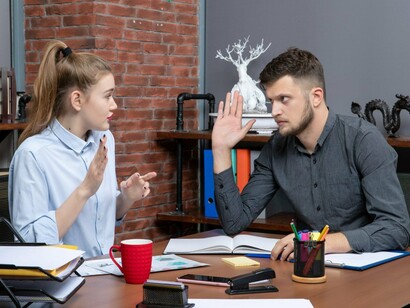 A tense workplace exchange between colleagues, representing the challenges of communication in polarized environments
