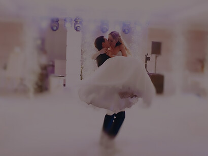 Evoke the romance of newlyweds with a captivating image of the groom lifting the bride during their wedding dance, epitomizing the joy of love and celebration