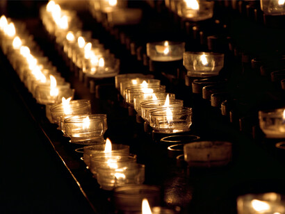 Votive candles lit in a row