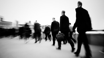 Morning commuters in London rush through the crowded streets, starting their workday