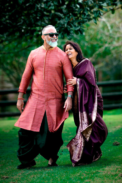 An elderly Indian couple, beaming with joy in their traditional outfits, captures the essence of love and cultural pride
