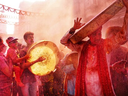 During Holi in Kolkata, West Bengal, colorful powder fills the air as people parade joyfully through the streets