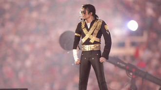 Michael Jackson posa com um dos figurinos mais emblemáticos de sua carreira, marcado por detalhes militares, fivelas e brilho. Na era Dangerous, o artista ampliou o uso da moda como ferramenta de expressão visual. O visual ajudou a consolidar uma das identidades estéticas mais reconhecidas da música pop