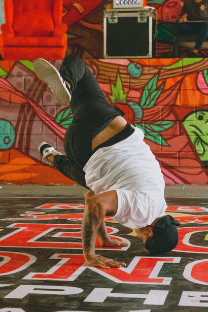 Man breakdancing in front of a graffiti wall