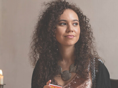 A woman engaged in Oracle card reading at a table