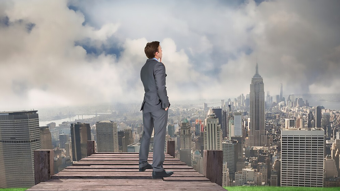 A man standing triumphantly atop a skyscraper, embodying success