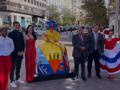 At the heart of Plaza Colón in Madrid, Spain, Ambassador Díaz Santana addresses attendees, celebrating the collaborative efforts of the Dominican Embassy and CEPM in showcasing Dominican heritage in the city