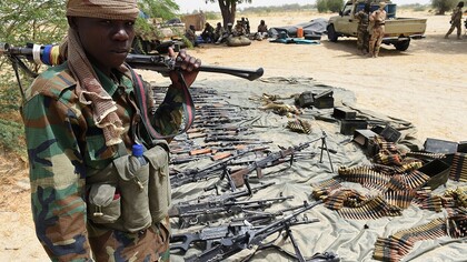 Un militar chadiano junto a un alijo de armas incautadas a Boko Haram