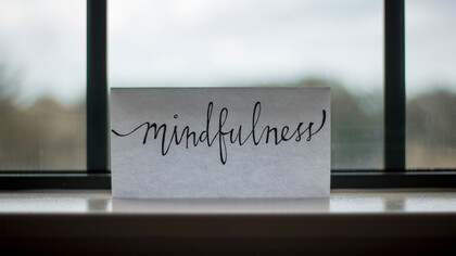Papel com escrita "mindfulness". O "Mindfulness" é a consciência plena que envolve observarmos os nossos pensamentos sem julgamento