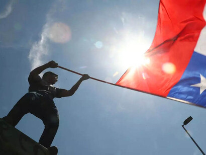 Ciudadano chileno ondea la bandera cono festejo por el resultado del plebiscito