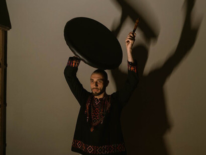 In the dim light, he immerses himself in the rhythm, using the drum as a powerful outlet for his emotions and inner struggles