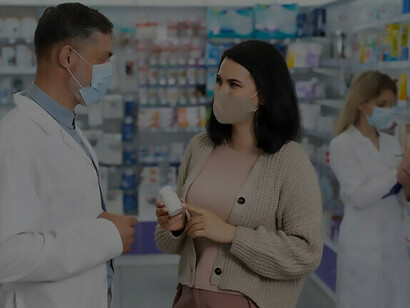 Un farmacéutico que ayuda a un paciente dispensando medicamentos recetados