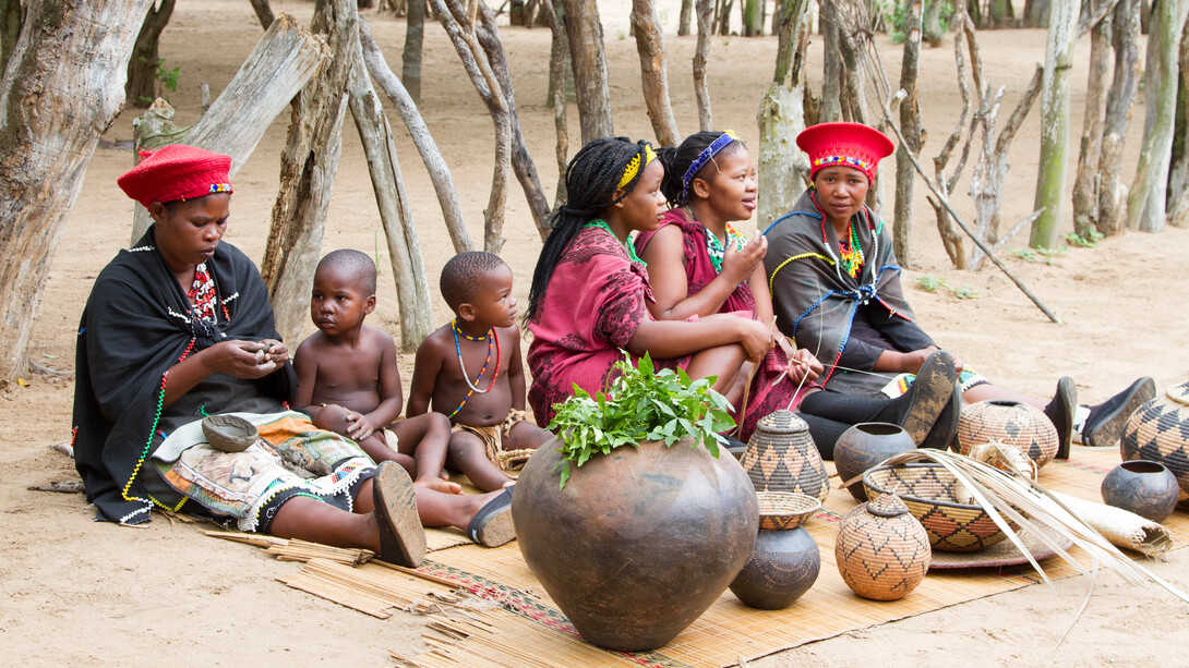 Zulu women share laughter and stories as they craft vibrant beads and intricate straw baskets, passing down cultural heritage to their children