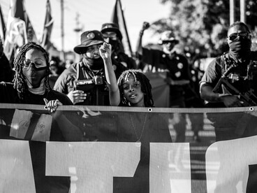 Protesters hold a banner at a Caribbean reparations march in Tulsa, Oklahoma, United States