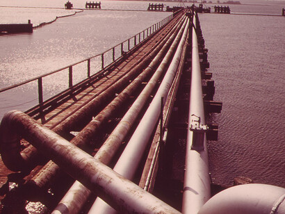 Pipelines extend from the dock of the Northeast Petroleum Tanker Terminal on Mount Hope Bay. To prevent oil spills, every ship and barge entering the terminal is surrounded by an oil containment boom