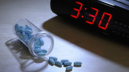 Pastillas para dormir junto a un reloj despertador