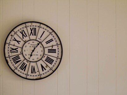A clock on a wall in roman numerals to illustrate time elapsing