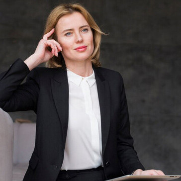 A reflective businesswoman engaged with a tablet, embodying the role of women in business, female leadership, and the impact of gender equality on economic progress