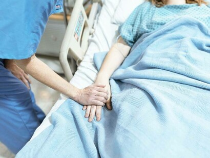 A nurse comforting a patient right before their PCOS surgery