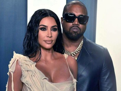 Kim Kardashian and Kanye West posing for pictures while attending the Vanity Fair Oscar Party in February 2020