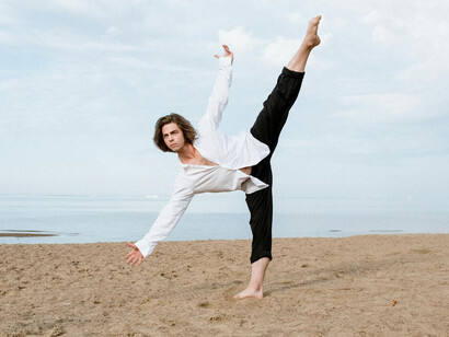 Hombre en la playa practicando danza
