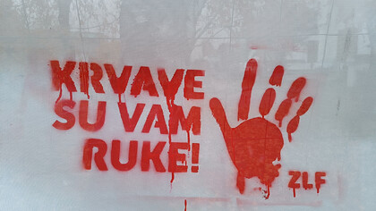 Red handprints with You have blood on your hands!, Serbian: Krvave su vam ruke!, Belgrade, Serbia
