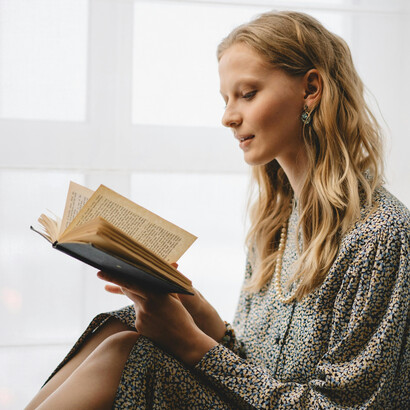 Woman reading a book in a library or study space