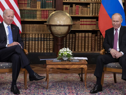 US President Joe Biden and Russian President Vladimir Putin sitting together talking