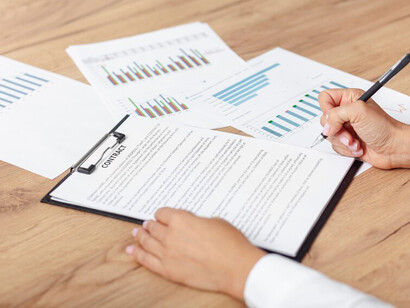 A business person examining contracts and documents as part of the job search and recruitment process, highlighting the relationship between employers and potential hires
