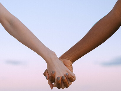 Two hands hold each other in trust and belief