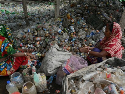 Women sorting through plastic bottles to try to make money