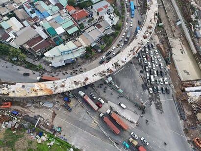 A congested intersection overshadowed by ongoing construction, symbolising the frustration of citizens waiting for promises of progress to become tangible improvements