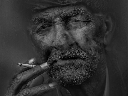 A man looking very old smoking