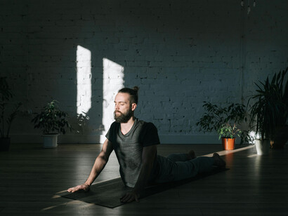 Praticante de yoga se alonga em posição desafiadora para a lombar. A ansiedade gerada pela crise climática afeta jovens, enquanto educadores buscam instilar esperança