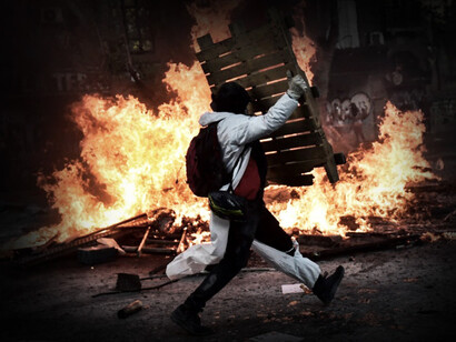 Hombre protesta junto a una barricada en llamas durante el 'Estallido Social' en Chile durante el año 2019