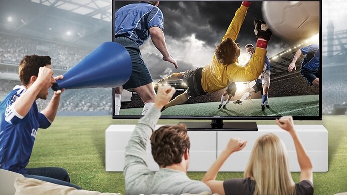 Grupo de amigos sentados en el sofá viendo el fútbol por televisión