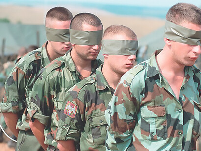 Marines from the 26th MEU oversee the transfer of Serbian detainees from Camp Bonsteil to Serbian authorities at the border, supporting peace and stability in Kosovo as part of Operation Joing Guardian