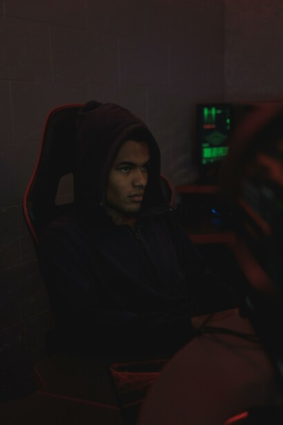 A person sitting at a computer in a dark room 