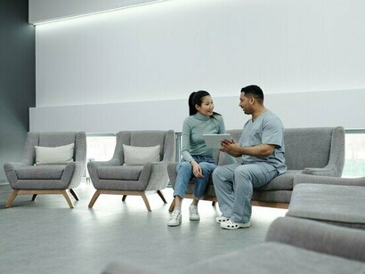 A patient reviewing information with a healthcare professional in a waiting area, representing the human impact of delayed access to care