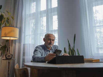 A senior citizen using his phone to remain plugged into the silver economy