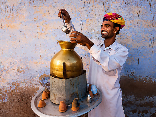 Street vendor preparing and serving masala chai in Jaipur, India
