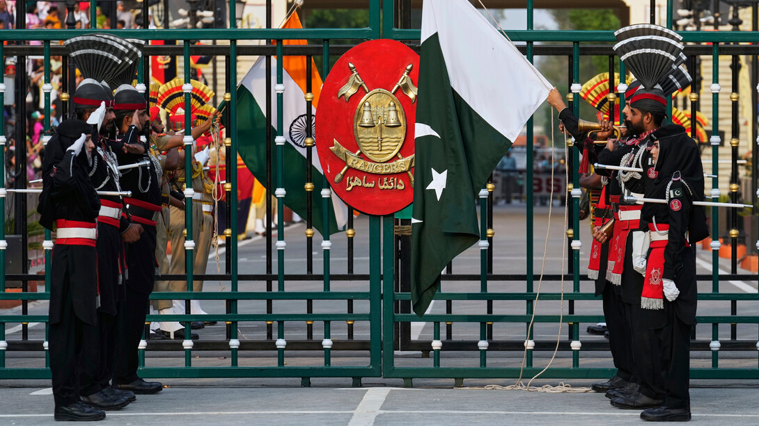 Soldados de Pakistán, vestidos de negro, y soldados de las Fuerzas de Seguridad Fronteriza de la India bajan sus banderas durante la ceremonia de clausura diaria en Wagah, un puesto conjunto en la frontera entre ambos países, cerca de Lahore, Pakistán, 3 de mayo de 2025