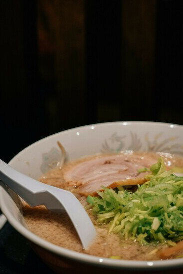 A bowl of ramen set against a black background