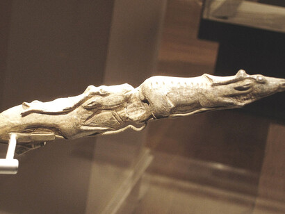 This carving of swimming reindeer is considered one of the most exquisite examples of Ice Age art ever discovered. Carved from the tip of a mammoth tusk and dating back around 13,000 years, it belongs to the end of the Last Ice Age—a time when mammoths, reindeer, and wolverines still roamed across Europe. It is now housed at the British Museum, UK