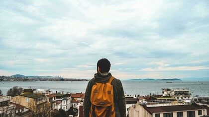 Homem contempla paisagem. Viver em um novo país é uma experiência que envolve muito mais do que aprender a viver em um novo lugar, na verdade, trata-se de descobrir uma nova versão de si mesmo e nem sempre as pessoas estão preparadas para isso