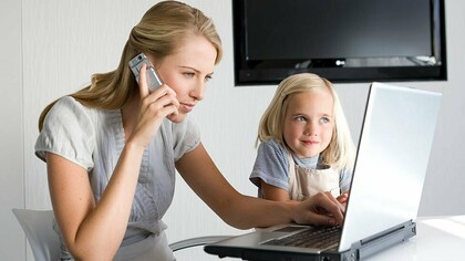 Una mujer trabaja desde casa junto a su hija