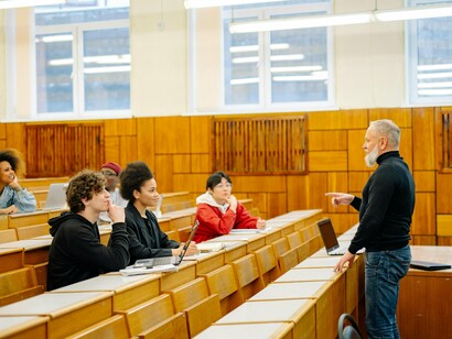 Sala de aula em universidade. Se estamos exaustos, ansiosos ou deprimidos, fica difícil ensinar, inspirar e se conectar com os alunos. Pense na gente como atletas mentais. Já viu algum corredor olímpico se preparando para uma maratona sem treinar, dormindo mal e comendo só junk food? Claro que não! Da mesma forma, precisamos cuidar da nossa saúde mental para dar nosso melhor em sala de aula