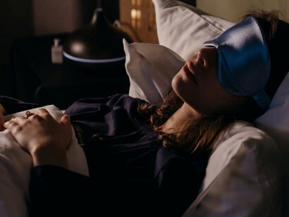 A deep sleeper adorned with a blue sleep band, depicted in surreal art that explores the mysterious realm of dreams and their connection to creativity