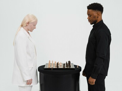 Two individuals studying a chessboard in thoughtful silence, reflecting the careful evaluation and critical thinking that underpin scientific inquiry